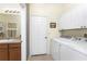 Functional laundry room featuring a washer and dryer, storage cabinets, and a adjacent wash room at 13392 Abercrombie Dr, Englewood, FL 34223