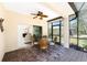 Covered patio with brick flooring, dining set, and seamless transition to the bright living room at 13392 Abercrombie Dr, Englewood, FL 34223