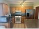Efficient kitchen with wooden cabinets, tile backsplash, and stainless steel refrigerator for storage and function at 13561 Darnell Ave, Port Charlotte, FL 33981