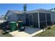 View of a home's back patio with outdoor furniture, screened-in porch, and yard at 13561 Darnell Ave, Port Charlotte, FL 33981