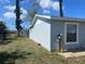 Rear view of a single-story home, showing the utility access point on the side of the house and partial fence at 13561 Darnell Ave, Port Charlotte, FL 33981