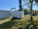 Metal storage shed in backyard, surrounded by green grass and trees at 13561 Darnell Ave, Port Charlotte, FL 33981