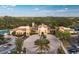 Sprawling community center complex featuring Mediterranean-style architecture, surrounded by lush landscaping and a large parking area at 142 Savona Way, North Venice, FL 34275
