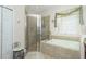 Bright bathroom with a glass shower, tile surround, and soaking tub at 142 Savona Way, North Venice, FL 34275