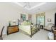Comfortable bedroom with a wrought iron bed, decorative lamps, and large windows for natural light at 142 Savona Way, North Venice, FL 34275