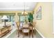 Dining room area with seating for six, chandelier lighting, and sliding doors to backyard pool at 142 Savona Way, North Venice, FL 34275