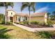 Inviting single-story home with lush landscaping, a brick walkway, and a beautiful terra cotta tile roof at 142 Savona Way, North Venice, FL 34275