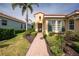 Beautiful home with lush landscaping, brick walkway, and stylish shutters on the windows at 142 Savona Way, North Venice, FL 34275