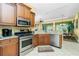 Open-concept kitchen with stainless steel appliances, granite countertops, and stylish tile flooring at 142 Savona Way, North Venice, FL 34275