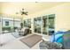 Covered lanai with comfortable seating, offering a relaxing outdoor space with views of the pool and backyard at 142 Savona Way, North Venice, FL 34275