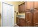 Well-organized laundry room features wood cabinets, utility sink, and ample counter space, providing convenience at 142 Savona Way, North Venice, FL 34275