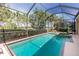 Relaxing screened-in pool area with a hot tub overlooking a lush green landscape at 142 Savona Way, North Venice, FL 34275