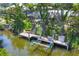 This is a waterfront home with a private dock and boat lift, surrounded by lush tropical foliage at 142 Sunaire Ter, Nokomis, FL 34275