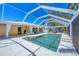 Backyard screened-in pool with patio, awning, and light blue sky at 142 Sunaire Ter, Nokomis, FL 34275