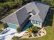 Aerial shot of house featuring a neutral facade, blue garage door, and manicured landscaping at 142 Yellow Pine Dr, Rotonda West, FL 33947