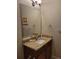 Well-lit powder room with a granite countertop vanity and a large mirror at 142 Yellow Pine Dr, Rotonda West, FL 33947