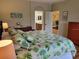 Well-lit bedroom with neutral walls, hardwood floors and direct access to en-suite bathroom at 142 Yellow Pine Dr, Rotonda West, FL 33947