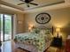 Comfortable bedroom featuring a tray ceiling, and a view of the pool area at 142 Yellow Pine Dr, Rotonda West, FL 33947