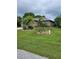 Charming single-story home featuring lush landscaping, mature trees, and a well-manicured lawn at 142 Yellow Pine Dr, Rotonda West, FL 33947
