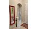 Inviting hallway with neutral paint, decorative mirror, and tile flooring throughout at 142 Yellow Pine Dr, Rotonda West, FL 33947