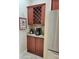 Butler's pantry with custom wine racks, granite counters, tile backsplash and stainless steel refrigerator at 142 Yellow Pine Dr, Rotonda West, FL 33947