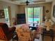 Bright living room featuring a ceiling fan and a sliding glass door with pool view at 142 Yellow Pine Dr, Rotonda West, FL 33947