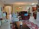 Open-concept living area with ceramic tile flooring that seamlessly connects to the dining area and kitchen at 142 Yellow Pine Dr, Rotonda West, FL 33947