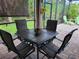 Inviting screened patio features a stone table and chairs, ideal for relaxed outdoor dining and entertaining at 142 Yellow Pine Dr, Rotonda West, FL 33947
