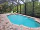 Private, screened-in pool is surrounded by a brick patio, offering an inviting outdoor retreat for relaxation and recreation at 142 Yellow Pine Dr, Rotonda West, FL 33947