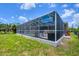 Exterior view of screened-in pool area with lush backyard and outdoor furniture at 143 Crevalle Rd, Rotonda West, FL 33947