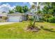 Well-maintained single-story home featuring a two-car garage and tropical landscaping at 143 Crevalle Rd, Rotonda West, FL 33947