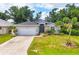 A beautiful single-story home with well-manicured lawn, lush landscaping, and a two-car garage at 143 Crevalle Rd, Rotonda West, FL 33947