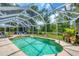 Refreshing pool in screened enclosure with tropical landscaping and sunny atmosphere at 143 Crevalle Rd, Rotonda West, FL 33947