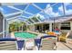 Inviting pool area with covered patio, lounge chairs, and a summer umbrella at 143 Crevalle Rd, Rotonda West, FL 33947