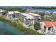 Aerial view of a waterfront condo community featuring a sparkling pool and lush landscaping at 1501 Beach Rd # 303, Englewood, FL 34223