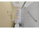 Bright bathroom featuring a shower with grab bar, toilet, and vanity mirror at 1501 Beach Rd # 303, Englewood, FL 34223