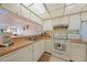 Kitchen with white cabinets, white appliances and pass-through to living area at 1501 Beach Rd # 303, Englewood, FL 34223
