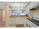 Kitchen with white cabinets, appliances, tile flooring and a passthrough to the living area with water views at 1501 Beach Rd # 303, Englewood, FL 34223