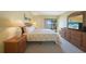 Bedroom featuring a queen bed, dresser, and a sliding glass door to the balcony with water views at 1501 Beach Rd # 303, Englewood, FL 34223