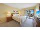 Bedroom with queen bed, balcony access with water view, and a light wood dresser at 1501 Beach Rd # 303, Englewood, FL 34223