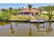 Beautiful waterfront home with screened-in pool, private dock, and lush landscaping, perfect for relaxing by the water at 15020 Acorn Cir, Port Charlotte, FL 33981