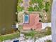 Bird's eye view of waterfront home with pool, private dock, and canal access, showcasing serene neighborhood from above at 15020 Acorn Cir, Port Charlotte, FL 33981