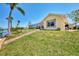 Spacious backyard with lush lawn and screened-in lanai, ideal for outdoor living and entertaining by the water at 15020 Acorn Cir, Port Charlotte, FL 33981