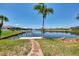 Picturesque backyard featuring a private dock, lush greenery, and serene waterfront views at 15020 Acorn Cir, Port Charlotte, FL 33981