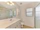 Bathroom featuring a vanity and a glass-enclosed shower with a window at 15020 Acorn Cir, Port Charlotte, FL 33981