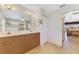 Bathroom featuring a double vanity, large mirror, and access to the main bedroom at 15020 Acorn Cir, Port Charlotte, FL 33981