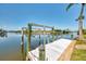Scenic waterfront view from the private dock with boat lift on a sunny day, perfect for boating enthusiasts at 15020 Acorn Cir, Port Charlotte, FL 33981