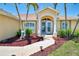 Inviting front entryway showcasing double doors, manicured landscaping, and stylish outdoor lighting at 15020 Acorn Cir, Port Charlotte, FL 33981