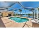 Refreshing pool with a screened enclosure, showcasing scenic views of the waterway and lush landscape at 15020 Acorn Cir, Port Charlotte, FL 33981