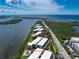 Aerial view of beachfront condos with a community pool, lush landscaping, and beautiful ocean views at 1551 Beach Rd # 212, Englewood, FL 34223